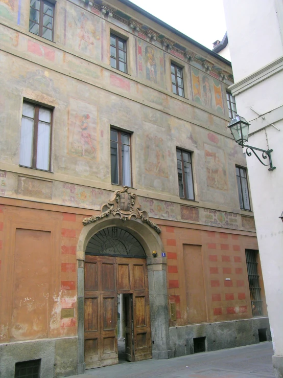 an old building with red and tan paint on the front