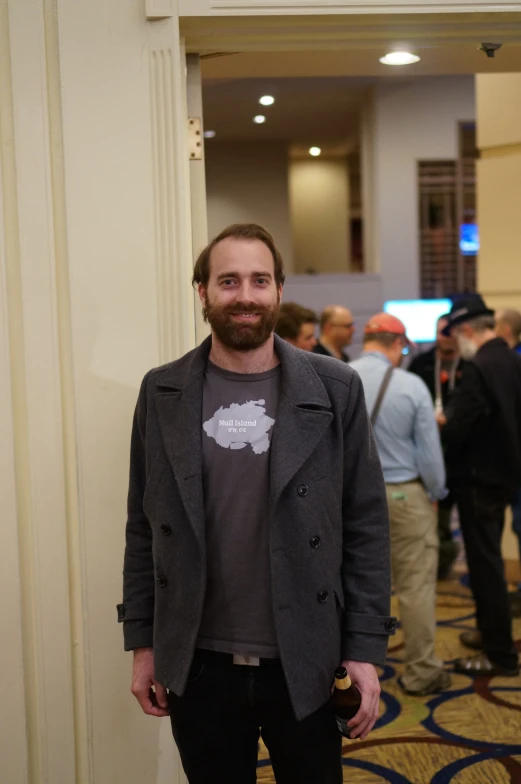 a bearded man wearing a jacket and smiling