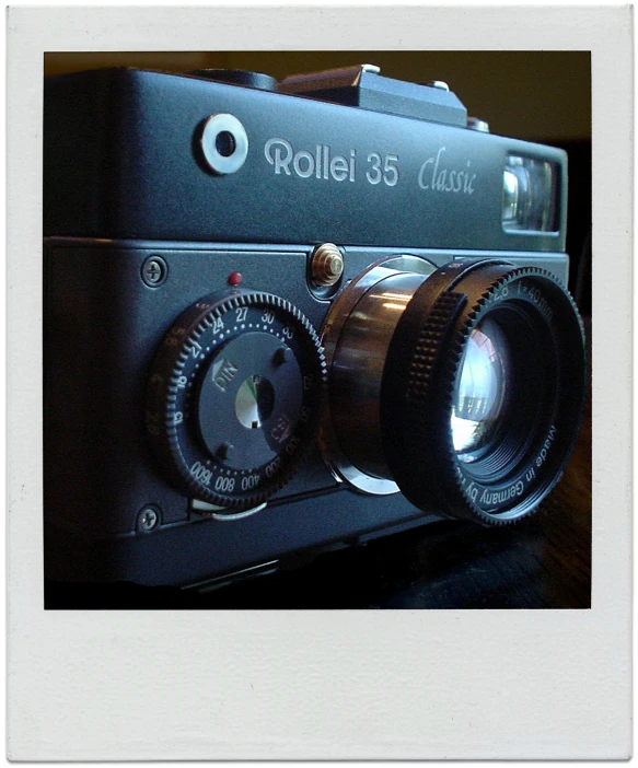 an old, black camera sitting on top of a wooden table