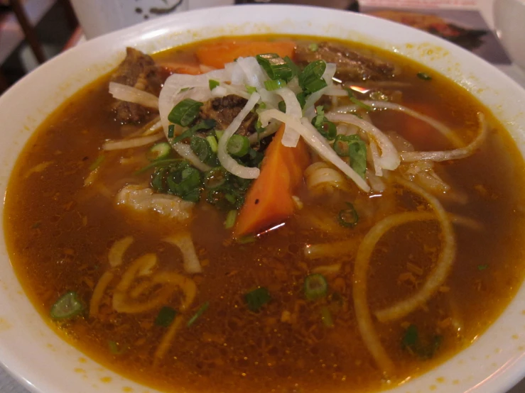 there is a bowl full of soup with meat and veggies