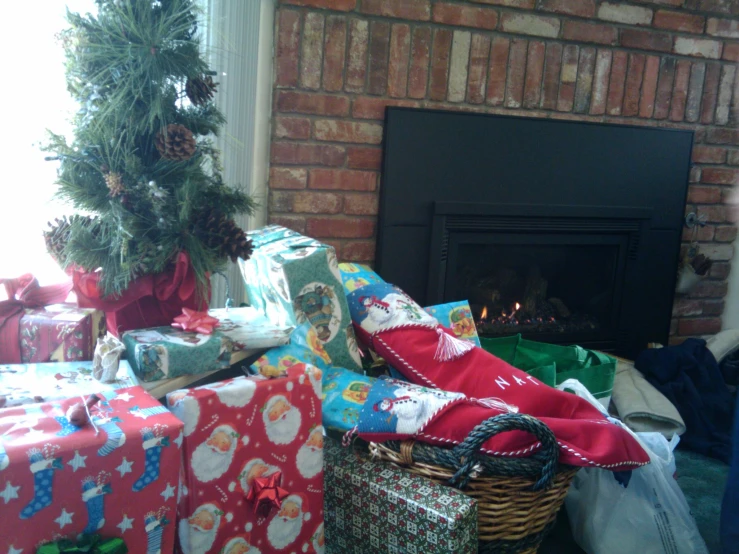 christmas presents wrapped up near fireplace and evergreen