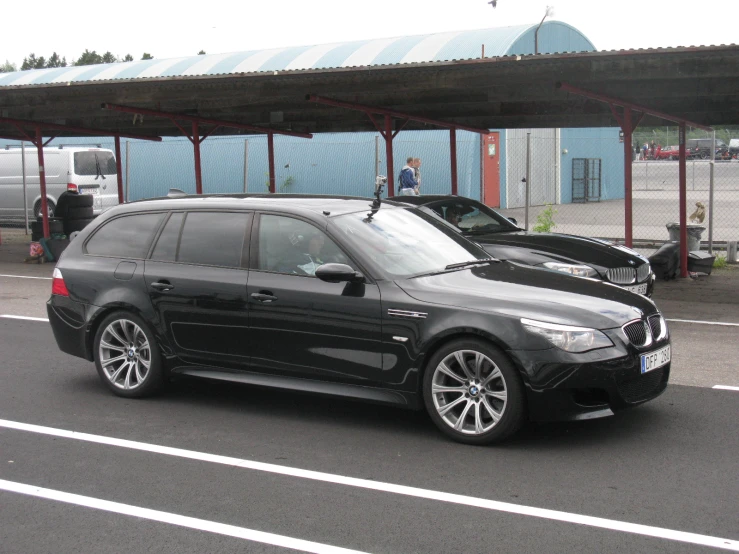 a black car sitting next to a large brown car