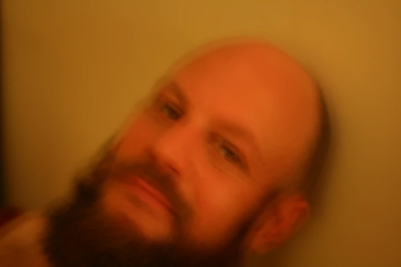 a bearded man looking ahead in a blurry po