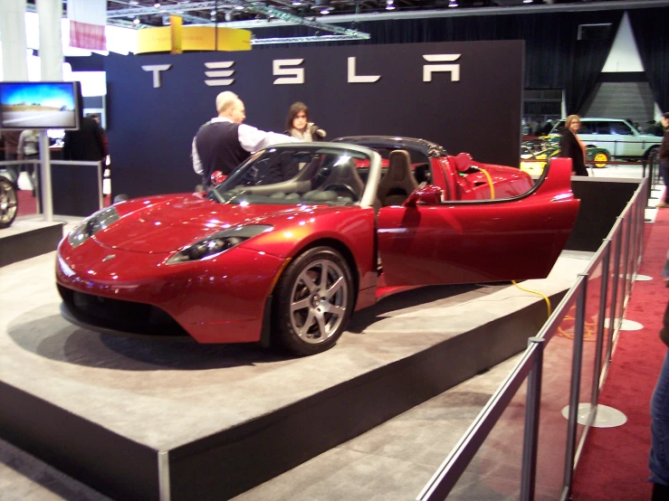 a red sports car with the doors open on display