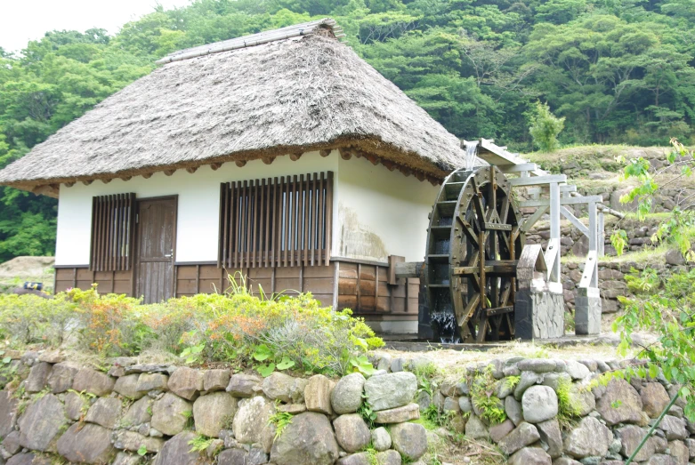 the water wheel sits outside of a building