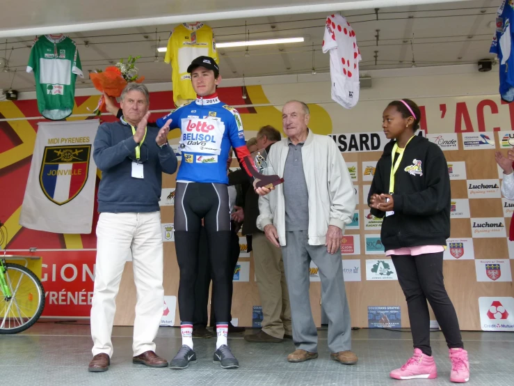 a group of people standing in front of a bicycle on a stage