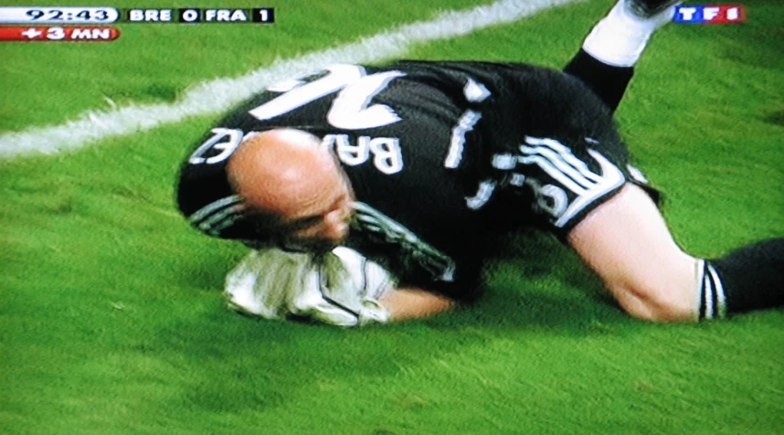 a soccer player falls on the ground as he gets injured