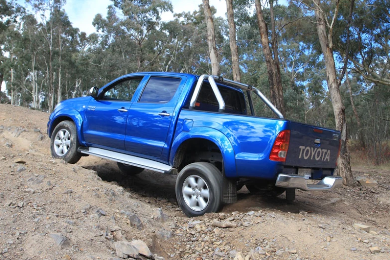 blue pick up truck on a dirt road