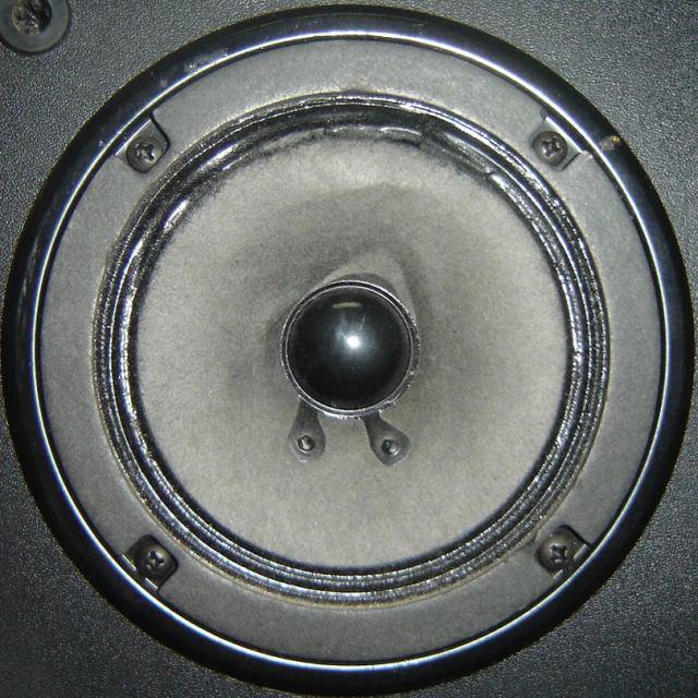 a close up of an electric speaker in a silver room