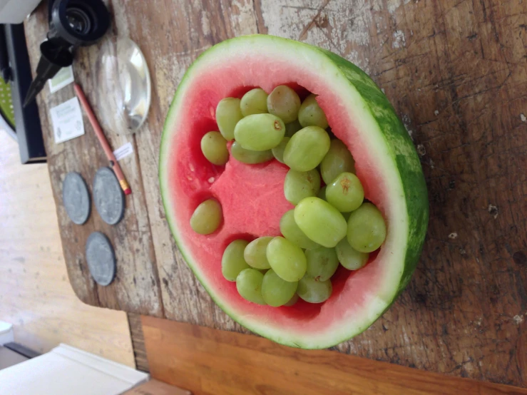 the watermelon is cut in half and has some gs in it