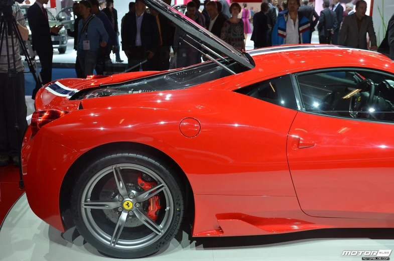 ferrari car on display at a show with people walking around