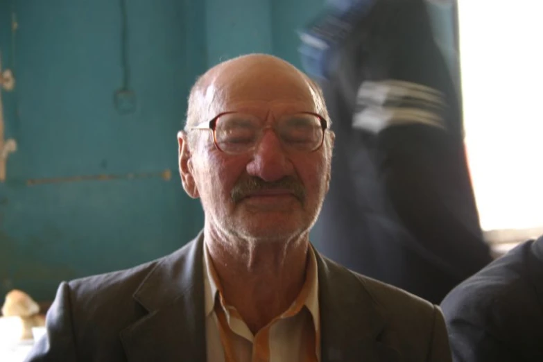 a man wearing glasses is in an old looking building