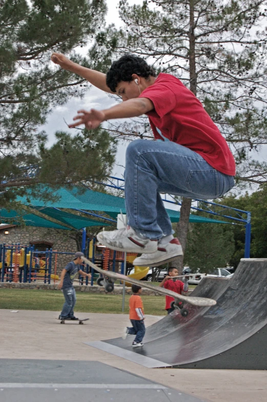 a skateboarder performing an ollie while a man watches