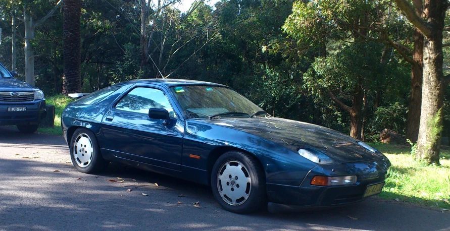 a blue sport car parked at the side of the road