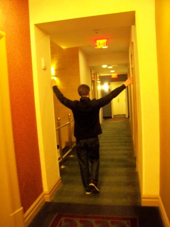 a man walking down the hallway towards another person