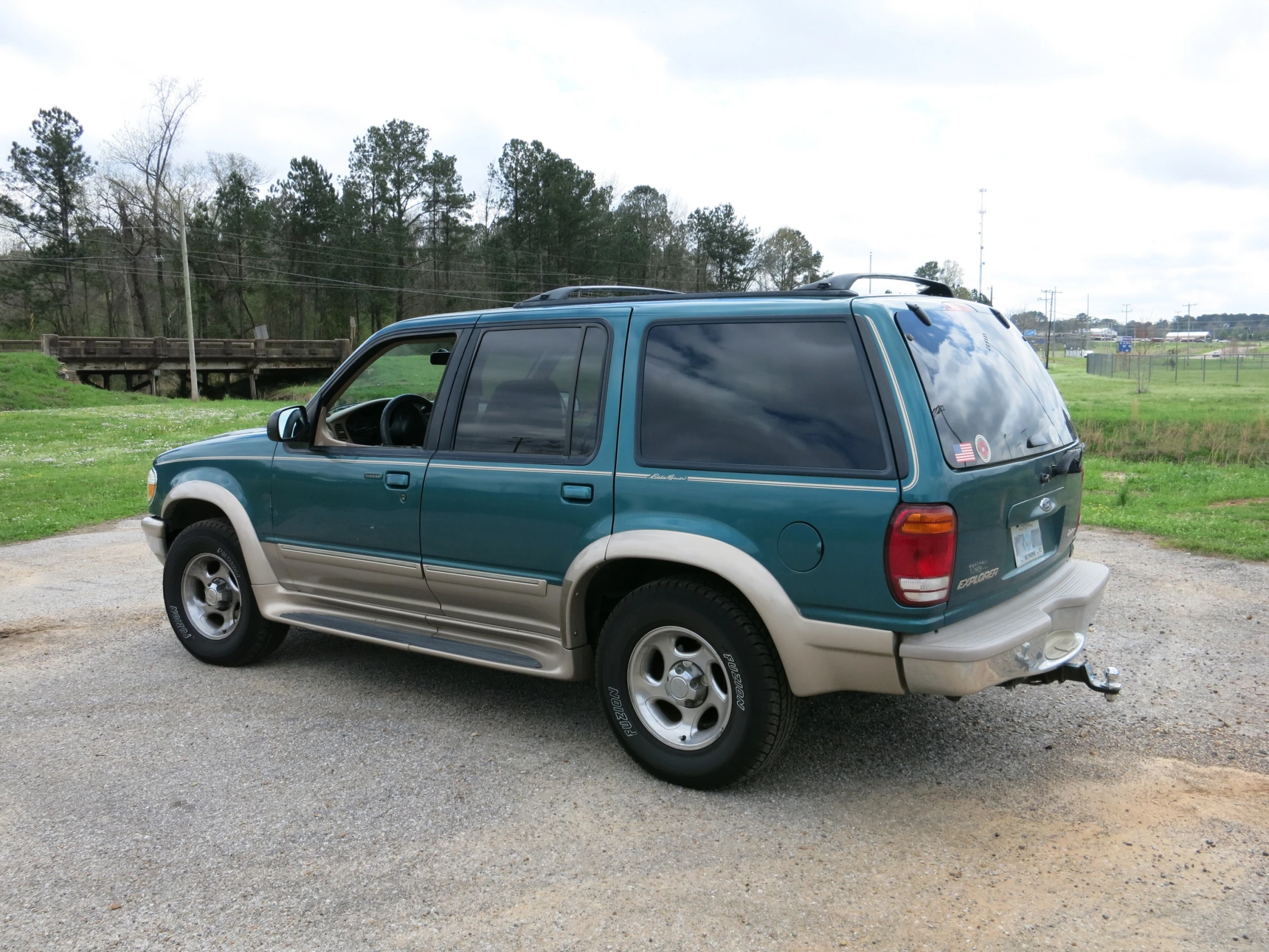 the rear end of a green suv parked in a parking lot