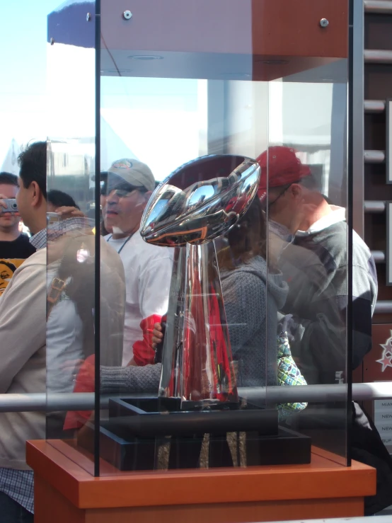 a woman is looking at a silver trophy