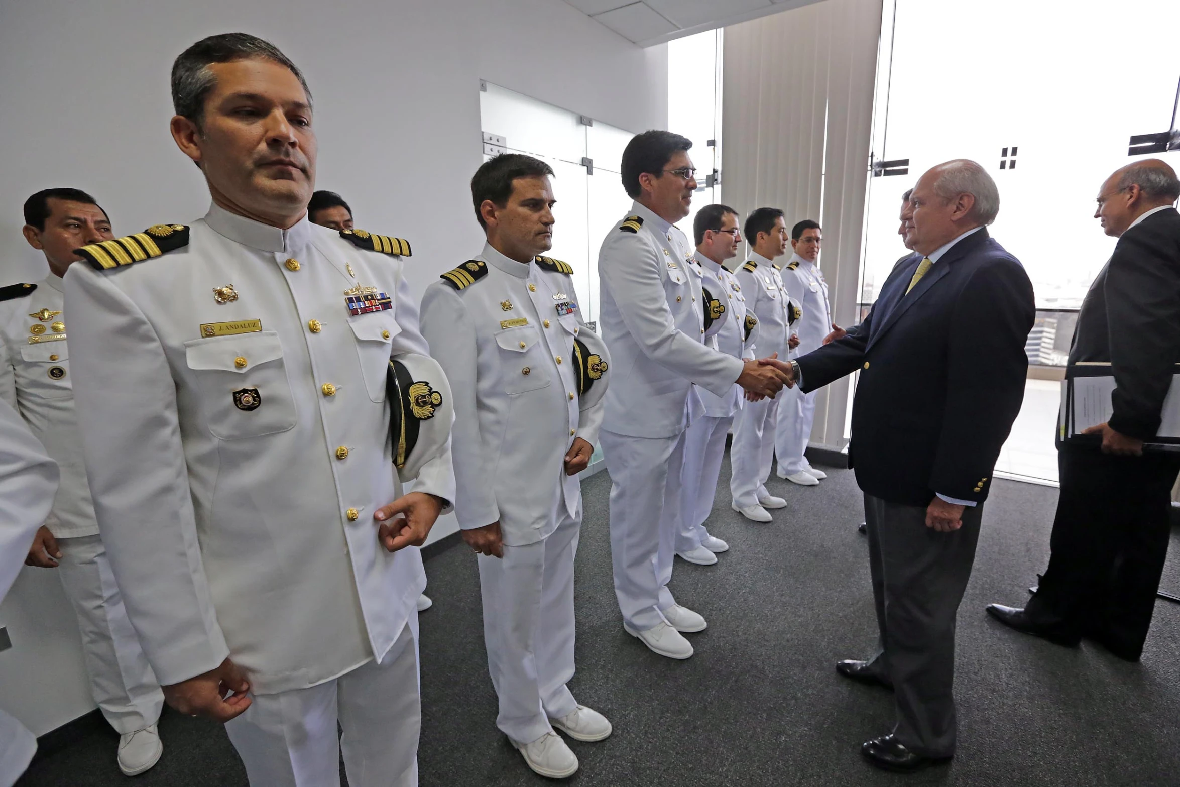 a few men in white uniform talking to one another