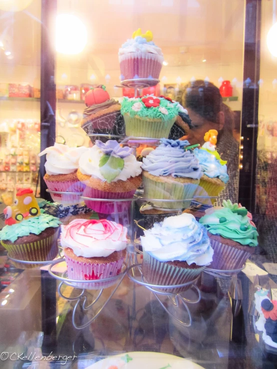 a variety of cupcakes on a tower with frosting