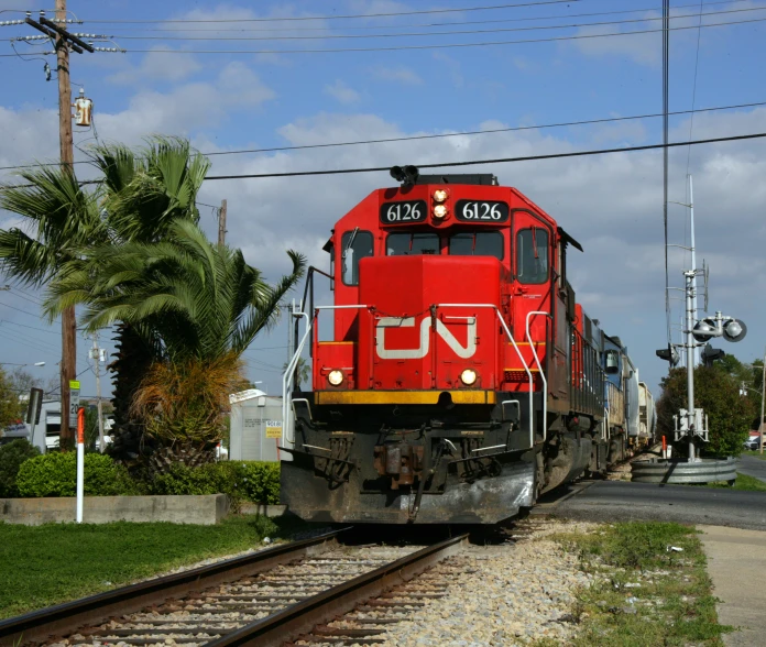 a red train engine sitting next to railroad tracks