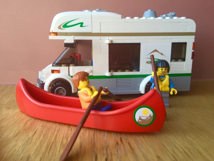 a toy boat with people in it sitting on top of a wooden floor