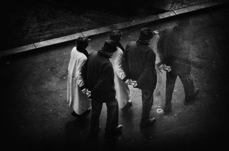 a group of men standing on a street near one another