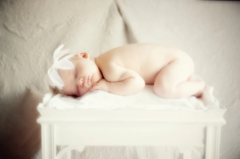 a baby is sleeping on the end of a crib