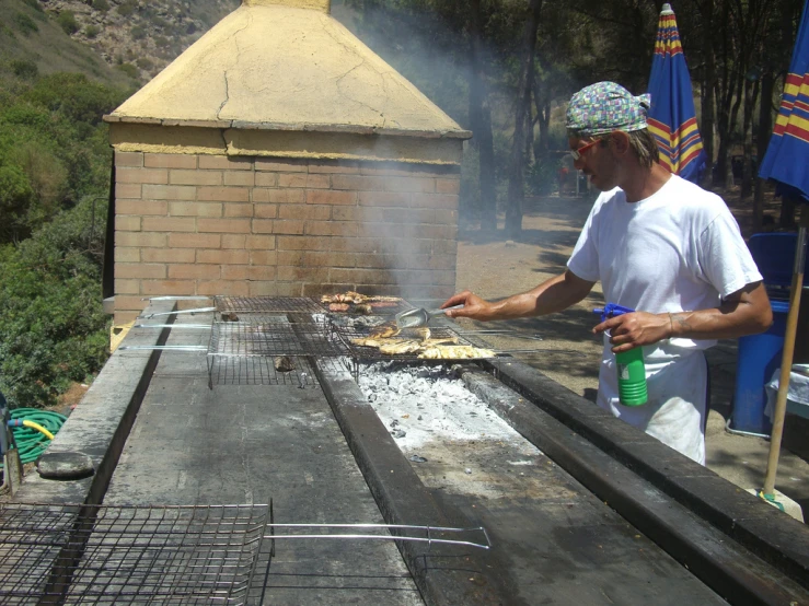 a person is cooking on a charcoal grill