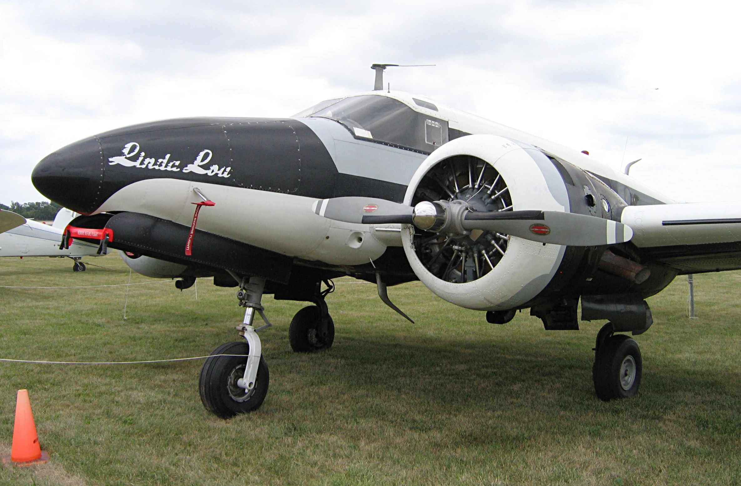 an airplane sitting on the grass by some cones