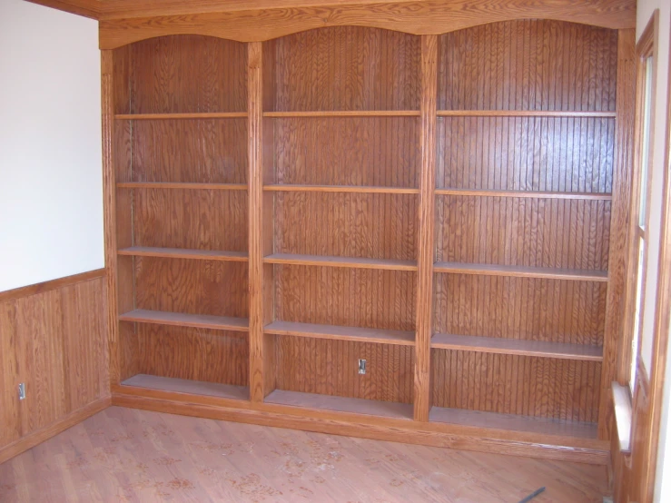 a room with a book case and wooden shelves