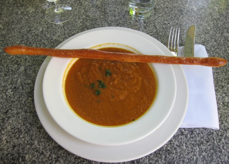 a plate with some kind of  dog next to some fork