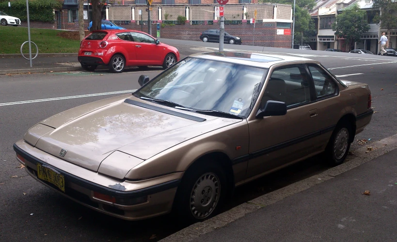 a gold car parked next to a sidewalk