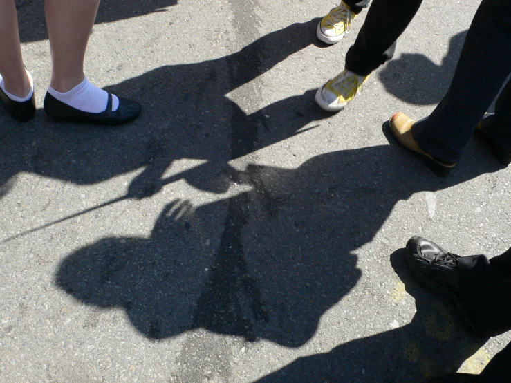 several people standing around in line casting shadows