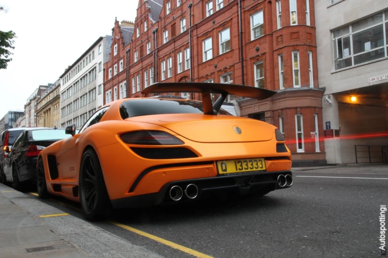 an orange sports car is parked on the street