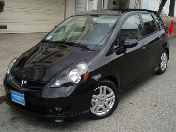 a small black colored compact vehicle parked in a lot
