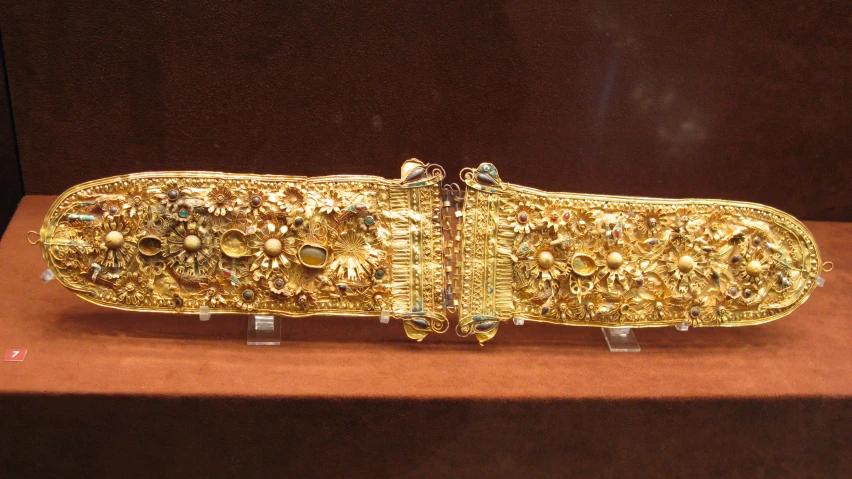 an ancient piece of gold jewelry that is displayed