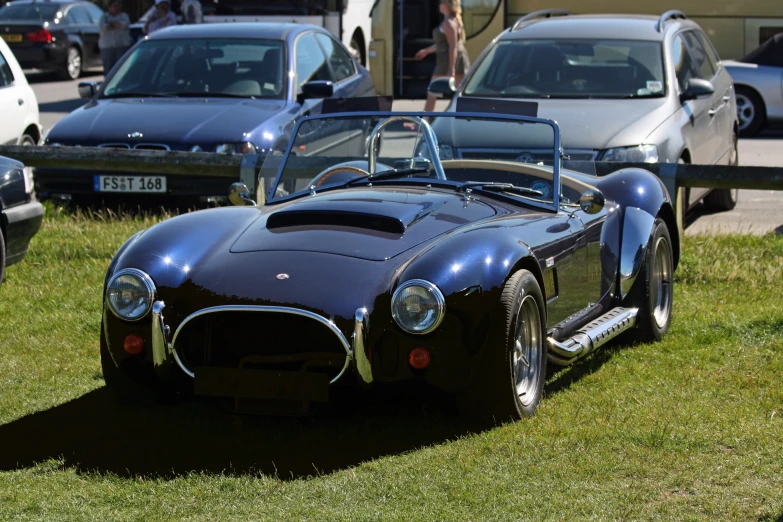 a close - up of a black car with chrome rims parked next to other cars