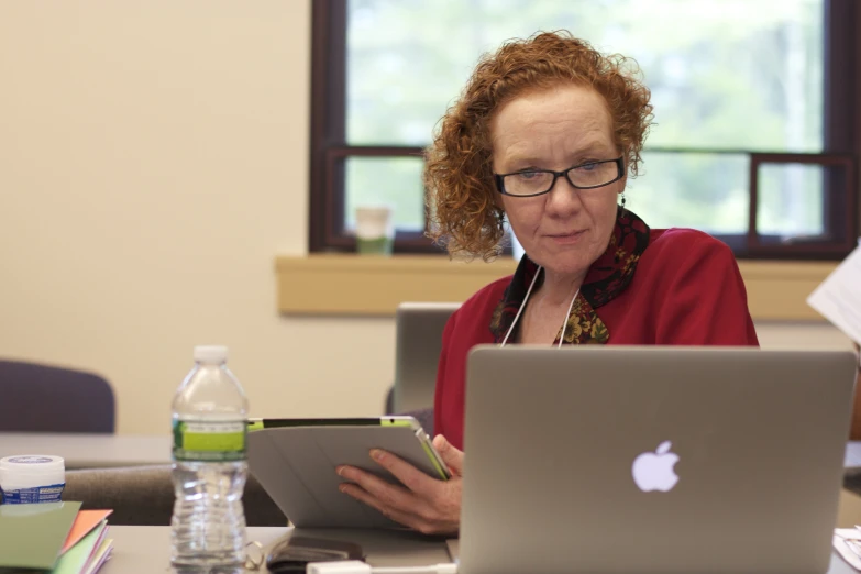 a woman at a laptop and a water bottle