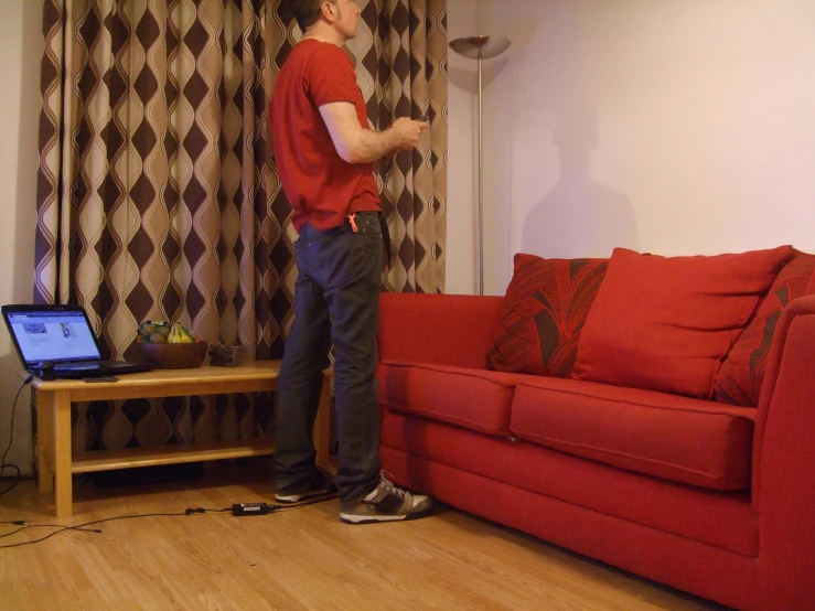 man in red shirt playing a wii game