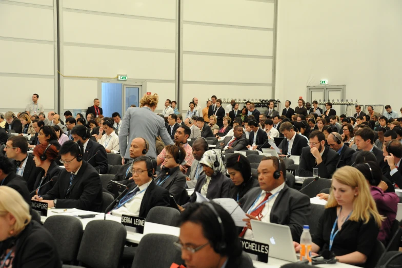 a lot of people sitting in rows of chairs with headsets