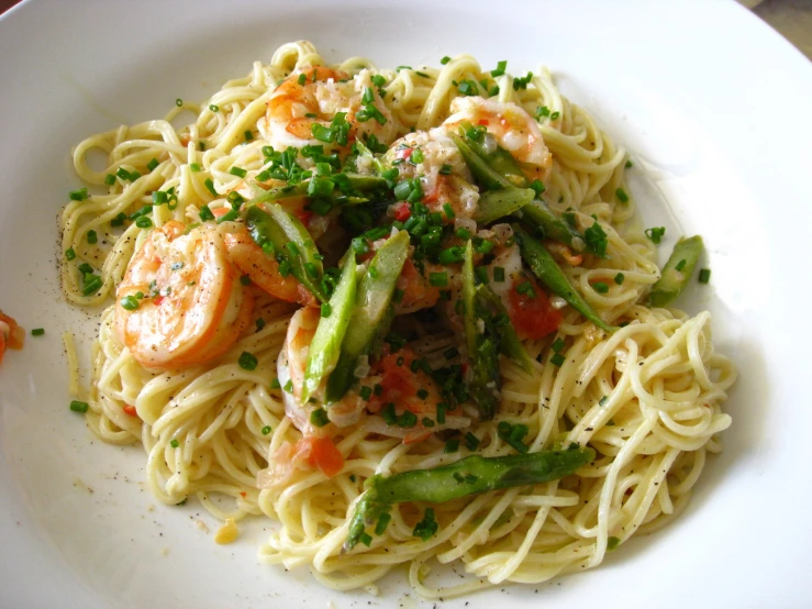 a dish with noodles, shrimp, and vegetables