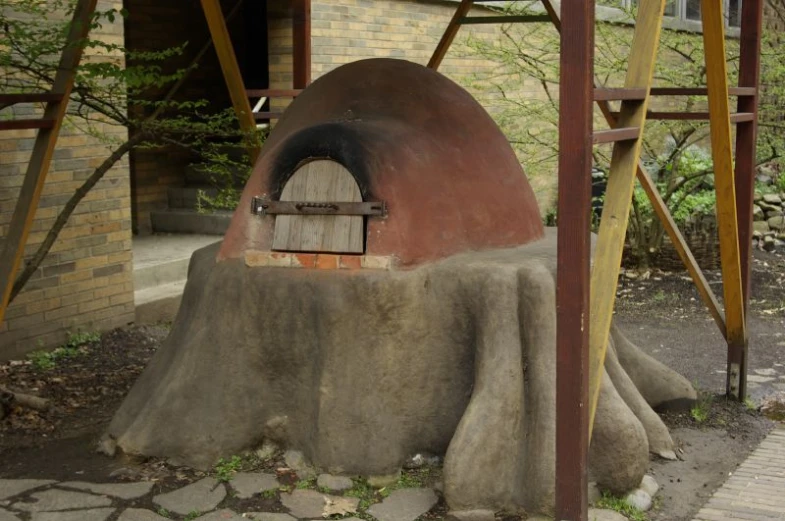 a large concrete oven with a wood door on it