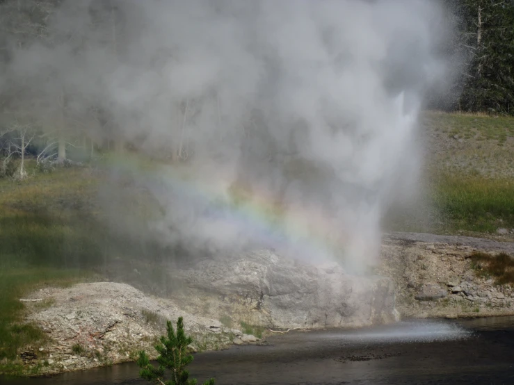 a very big and pretty geyser with a rainbow