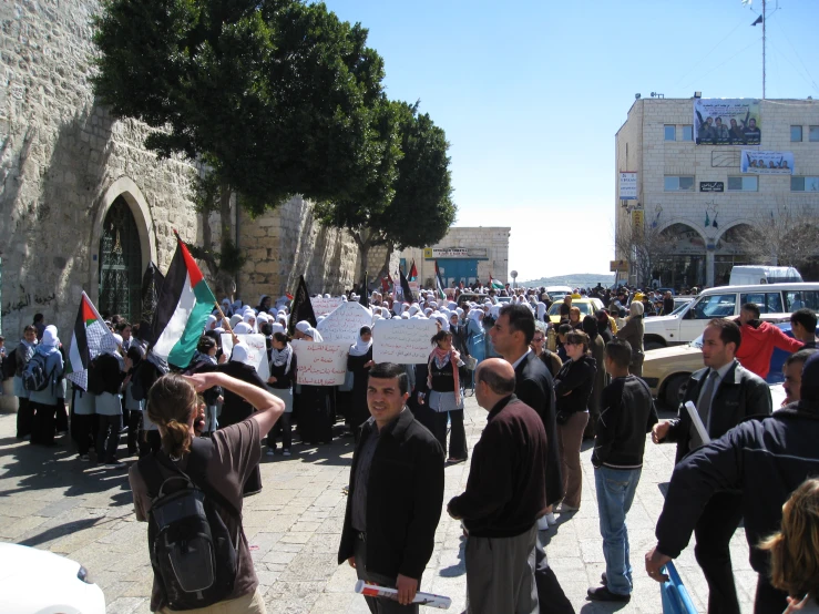 a large group of people are holding signs and flags