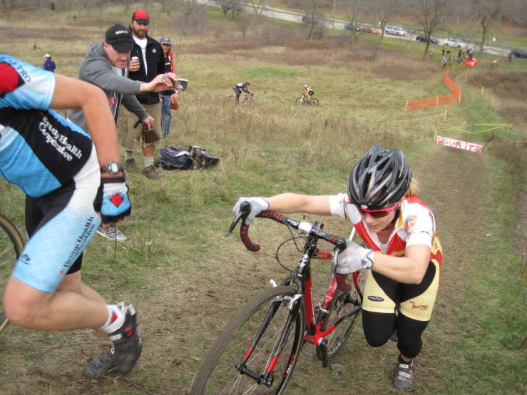 several cyclists taking part in a race while their teammate is stopped