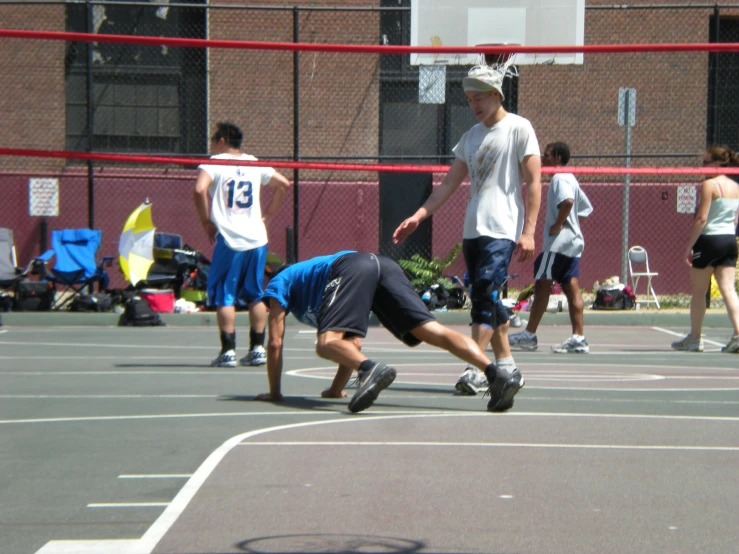 a man falling down on a basketball court