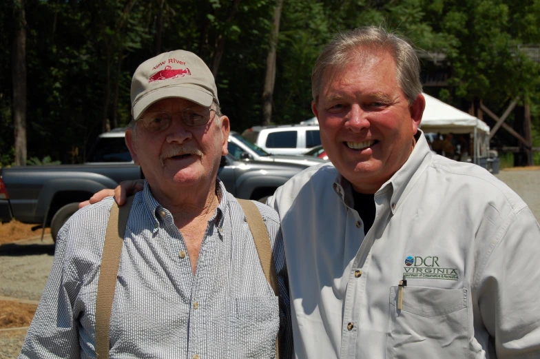 two men standing together in a lot full of trucks