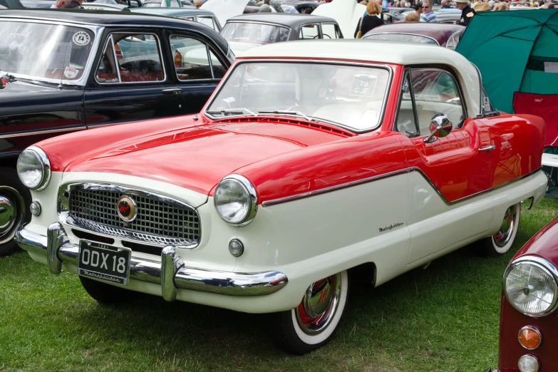 old time cars parked on the grass at an outdoor gathering