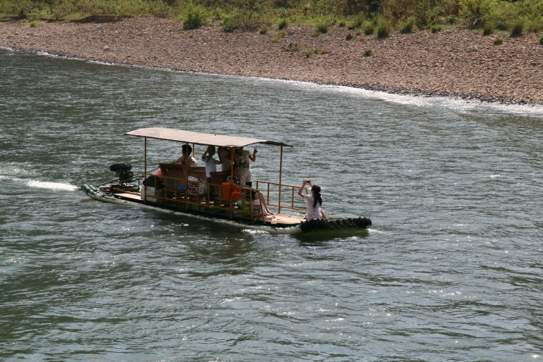 a small boat traveling on a river next to a forest