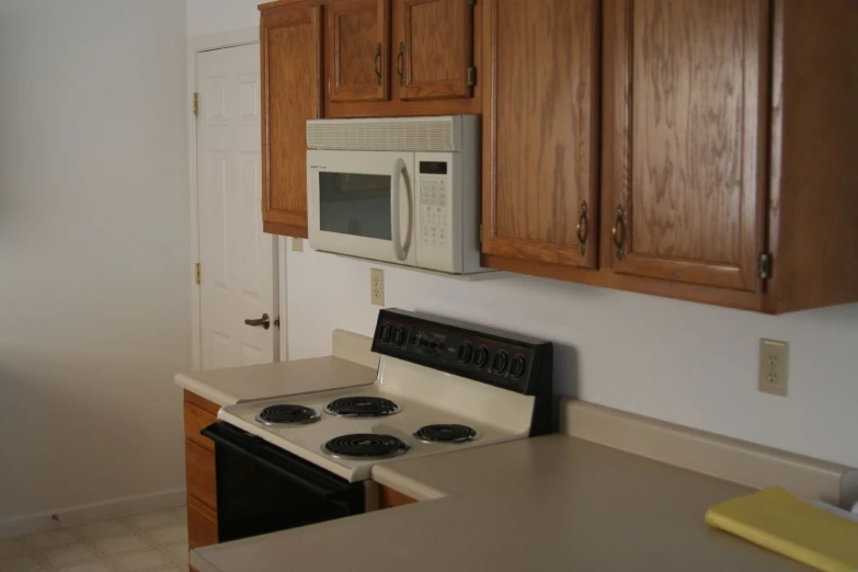 a kitchen with a microwave and stove with wood cabinets